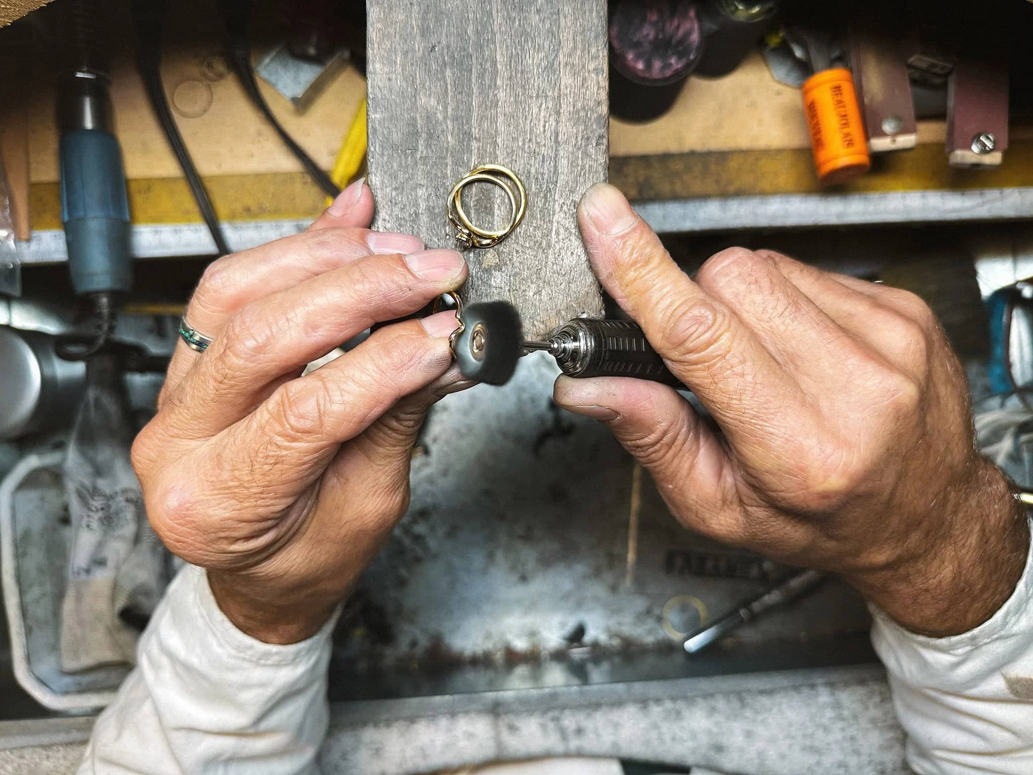Gros plan sur les mains d'un homme en train de polir une bague en or