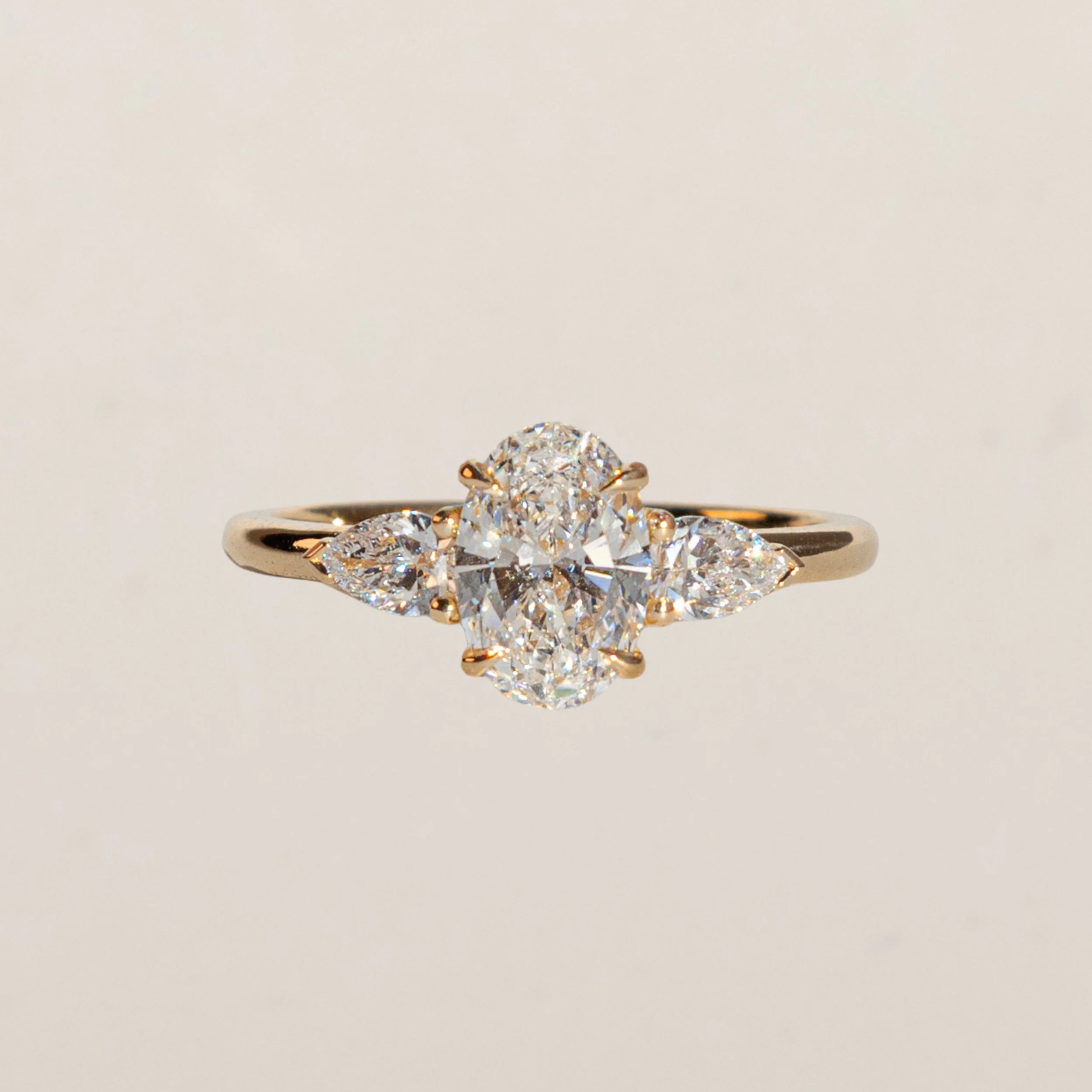 Bague de fiançailles trilogy en or jaune 18 carats avec diamant ovale central et deux diamants poire – joaillerie Zephyrade