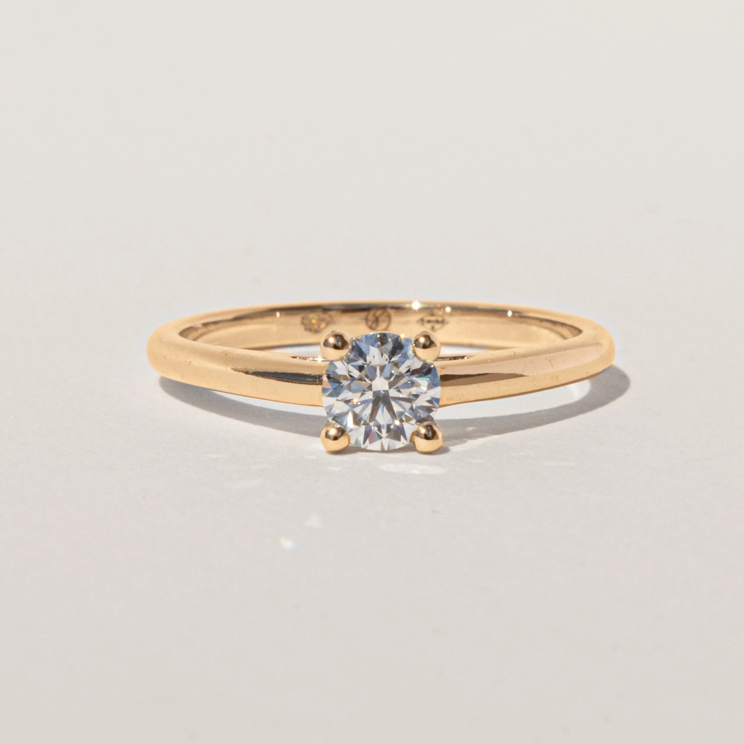 Bague de fiançailles solitaire Héloé avec diamant rond taille brillant, naturel ou de laboratoire, monté sur une monture cathédrale minimaliste en or 18 carats recyclé.